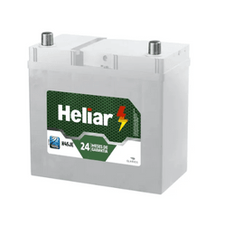 Car battery with white casing and a green Heliar label, showing 24 (months) warranty on the front badge.